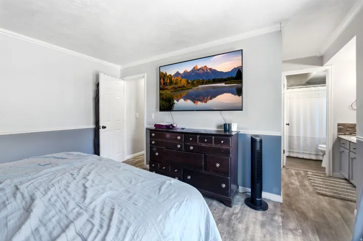 Wood-finish flooring throughout, complemented by a two-tone wall treatment and crown molding