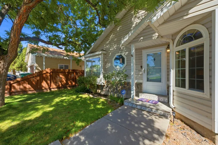 Front exterior featuring siding, stone accent base, bay window, arched transom window, and concrete walkway
