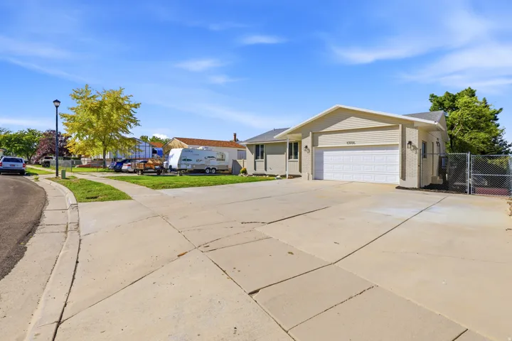Property exterior featuring a concrete driveway, attached garage, and chain link fencing