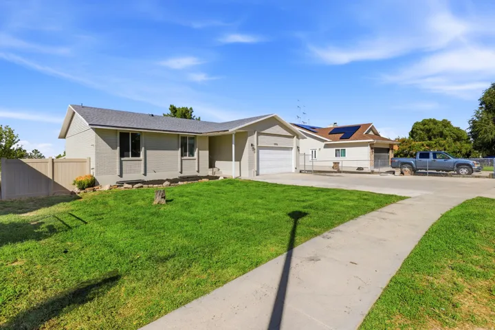 Ranch-style exterior with a gray-toned facade, attached garage, and a concrete driveway