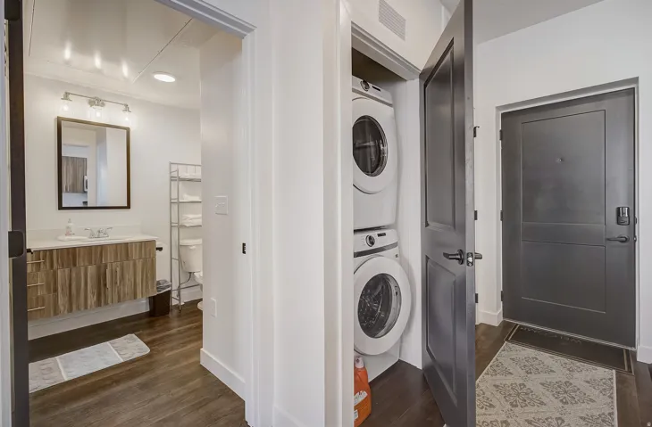 Integrated stacked washer and dryer within a dedicated closet