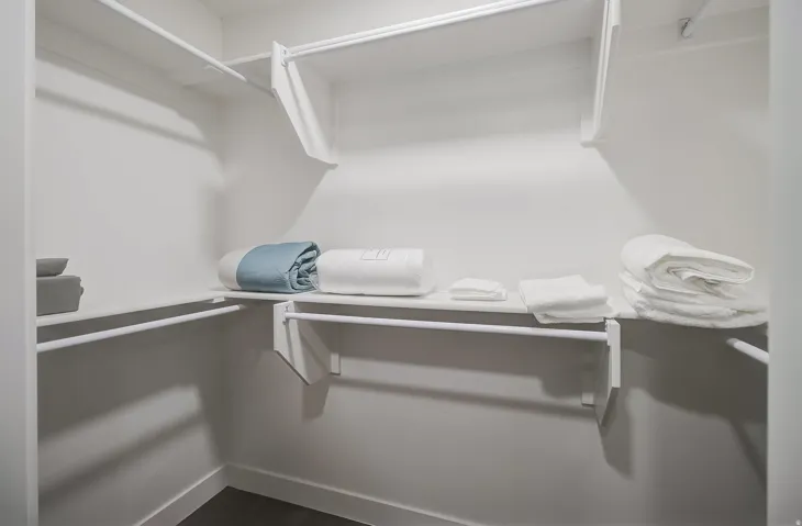 White wall-mounted shelving and hanging rods