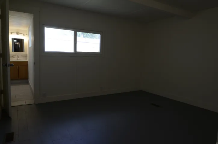 Room featuring dark wood-finish flooring and a double-pane window