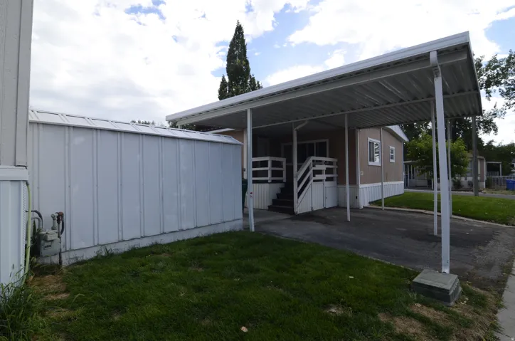 Covered carport, dedicated exterior storage structure, and ground-level entry