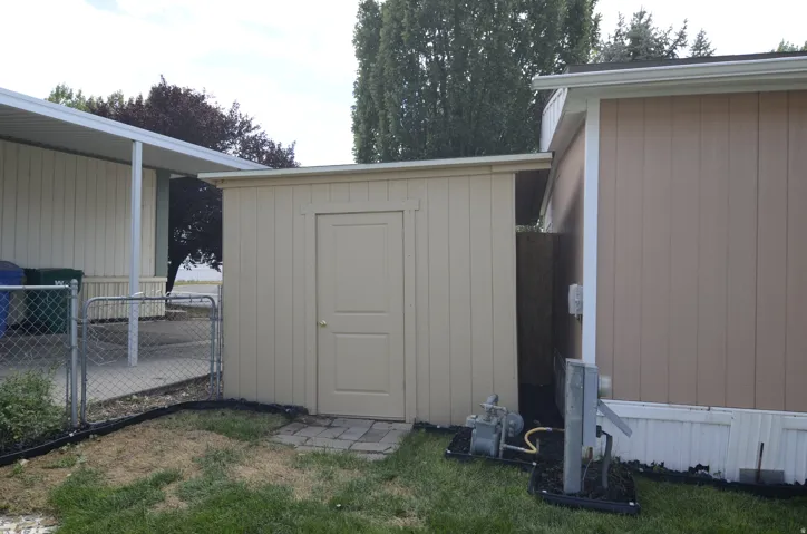 Storage shed with a paneled door and brick paver entry