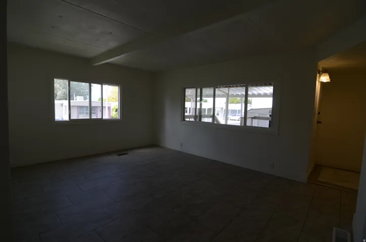 Expansive room with tile flooring, multiple windows, and a flush-mounted ceiling light fixture