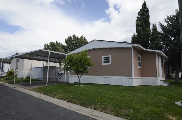 Brown siding exterior with white trim and a white skirting
