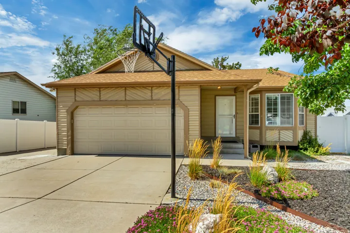 Single-story residence featuring an attached garage, a concrete driveway, and a front porch