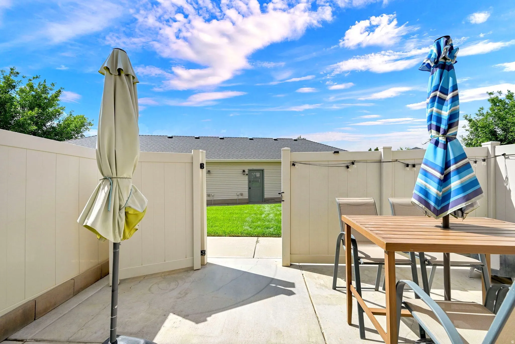 Private patio space with concrete paving, fully fenced perimeter, and string lighting