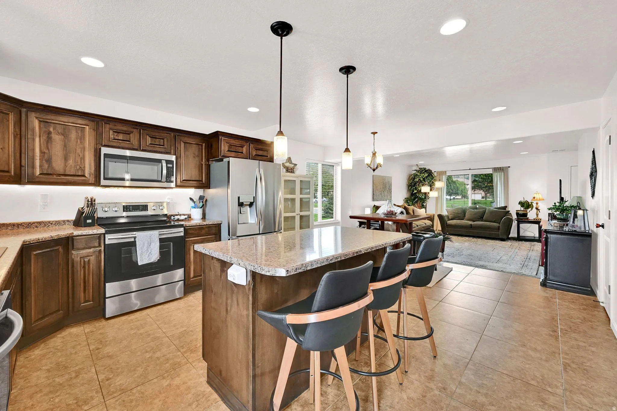 Kitchen featuring wood cabinetry, stainless steel appliances, and a central island with a light-toned countertop