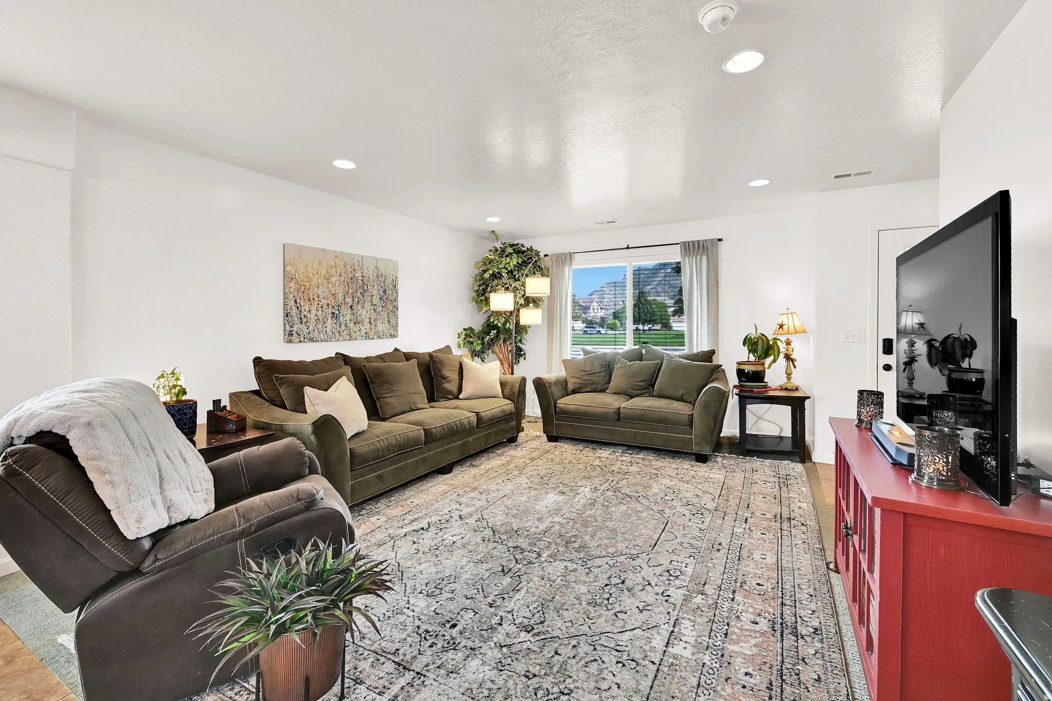 Recessed ceiling lighting illuminates this bright interior space with white walls and a light-colored door