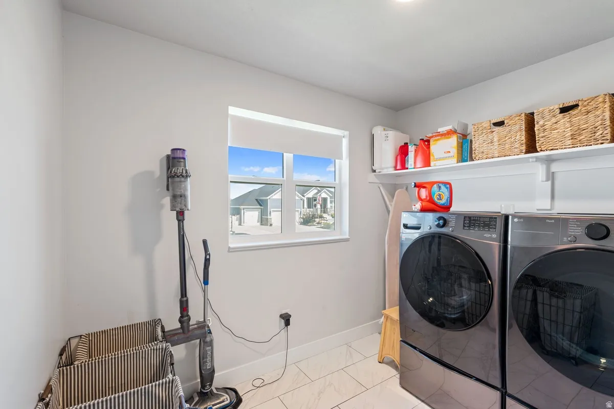 Laundry area with a window, overhead shelving, and tile flooring