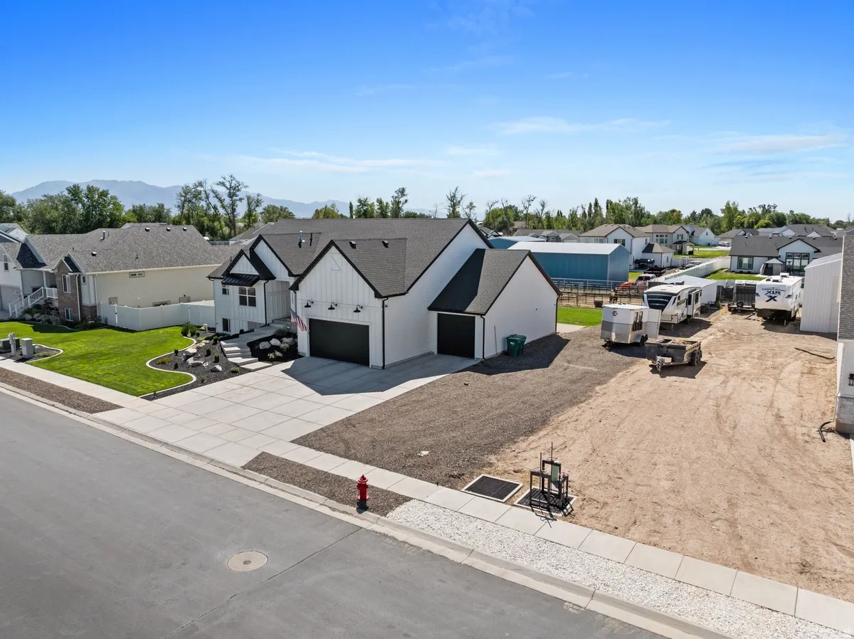 Modern farmhouse-style exterior with black trim, dark roofing, and white vertical siding