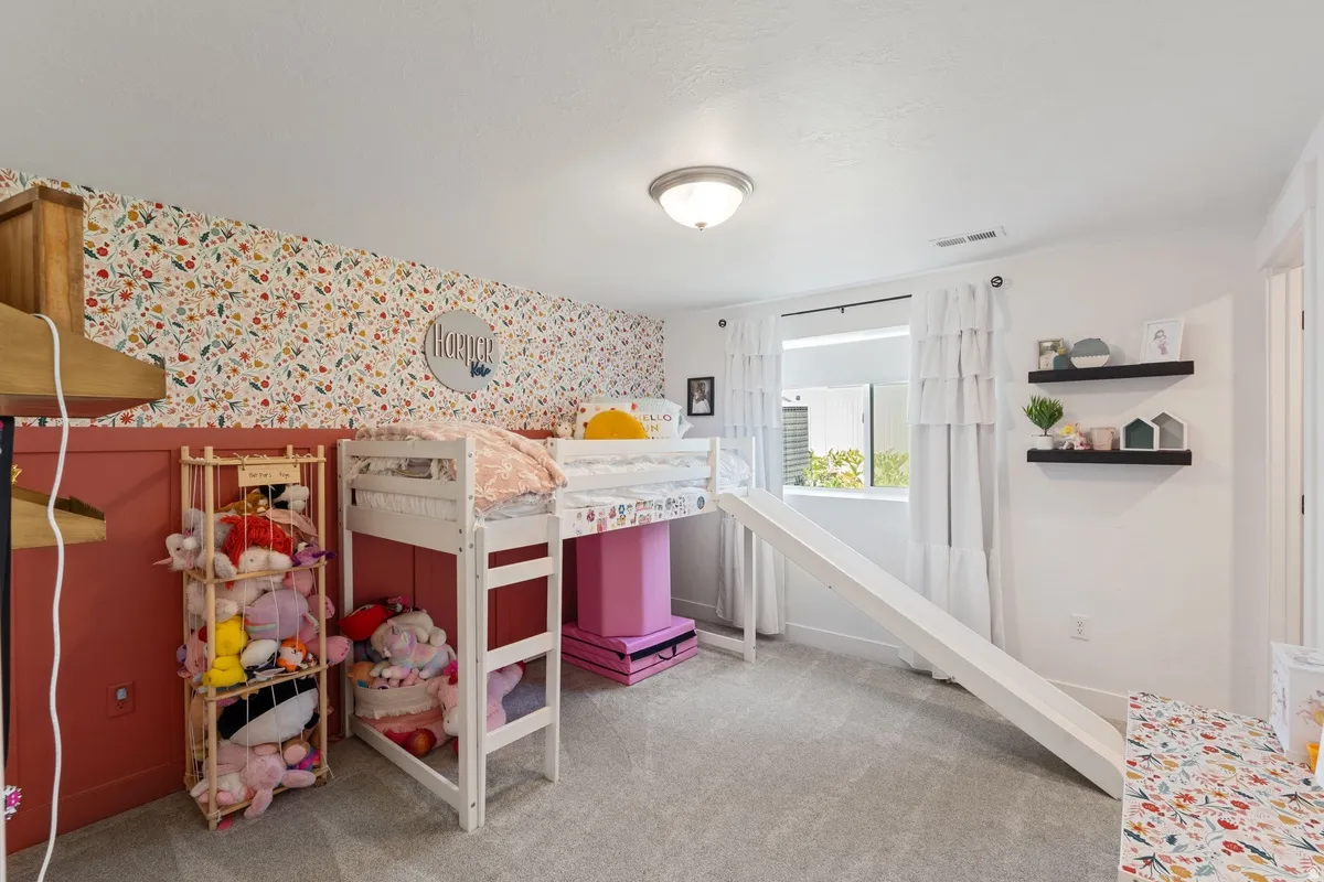 Carpeted room featuring a white-framed window, two floating shelves, and a ceiling-mounted light fixture