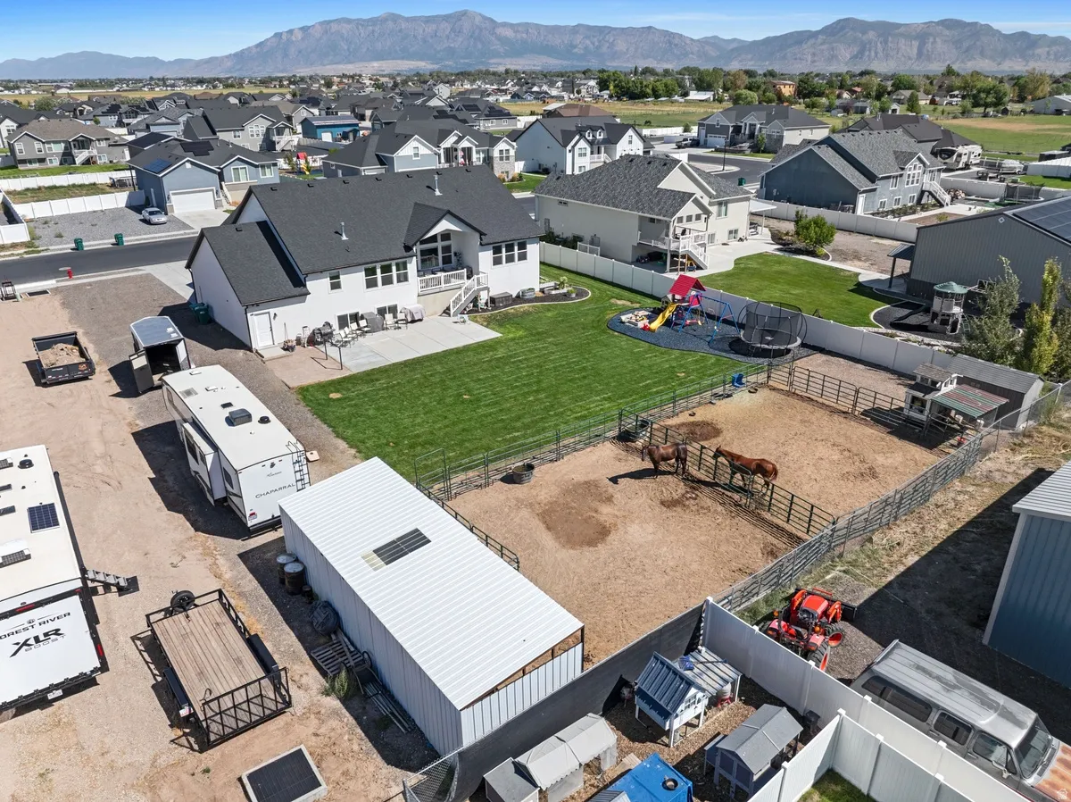 White two-story residence featuring a dark shingle roof and an expansive lawn
