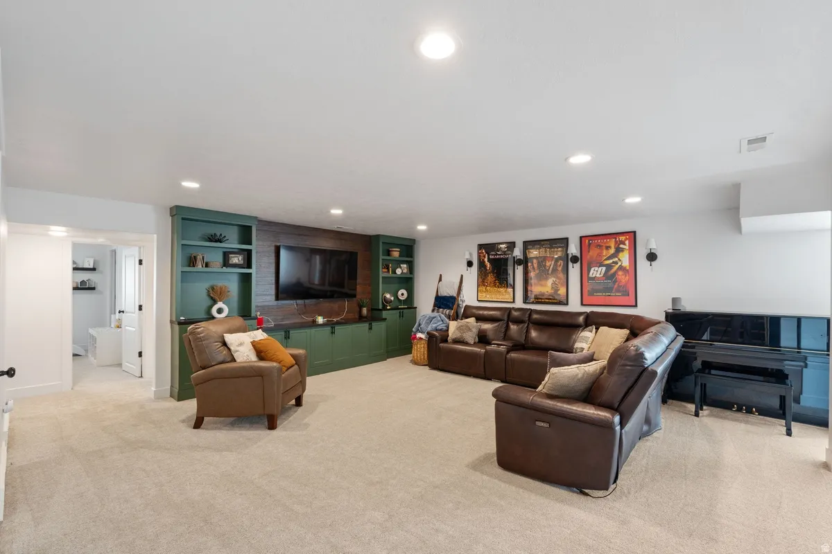 Built-in shelving with integrated cabinetry, recessed lighting, and soft carpet flooring