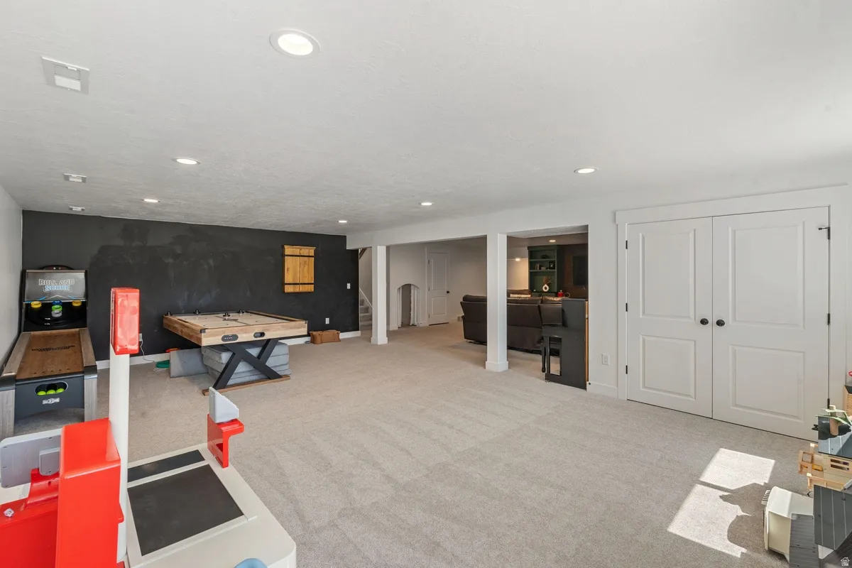 Expansive carpeted area with recessed lighting, offering versatile use