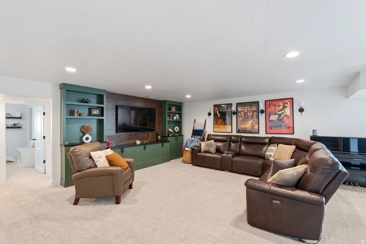Built-in entertainment center featuring green cabinetry and wood-finish accent wall