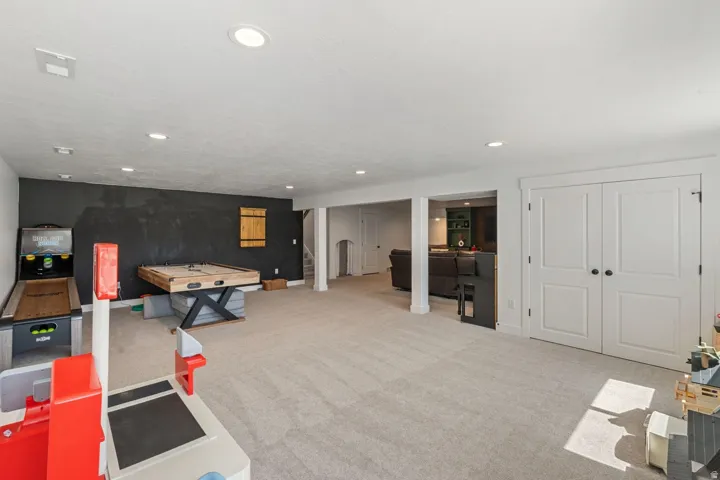 Expansive carpeted area with recessed lighting, offering versatile use