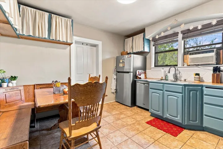 Kitchen featuring blue cabinetry, a stainless steel refrigerator, and wood-finish countertops