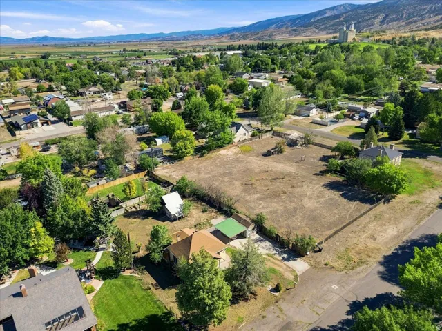 Expansive lot featuring a large open area, perimeter fencing, and established trees