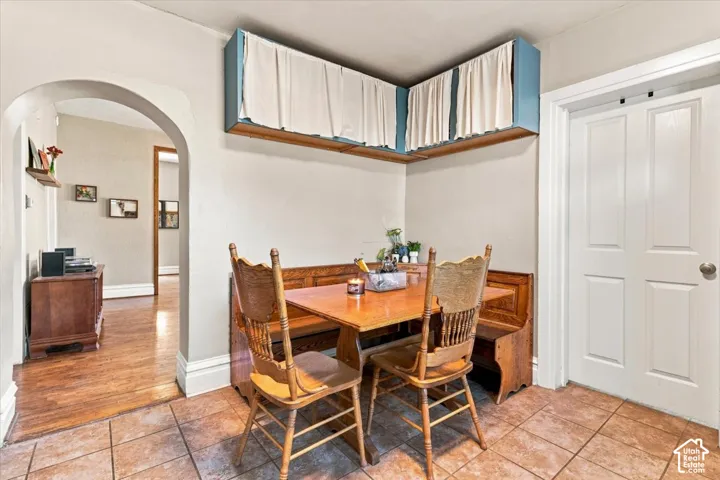 Tile flooring, arched doorway, wood-finish flooring, white paneled door