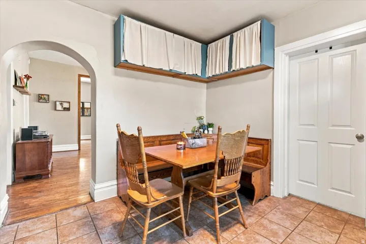 Tile flooring, arched doorway, wood-finish flooring, white paneled door