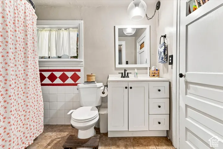 White vanity with ample storage, integrated sink, and black faucet