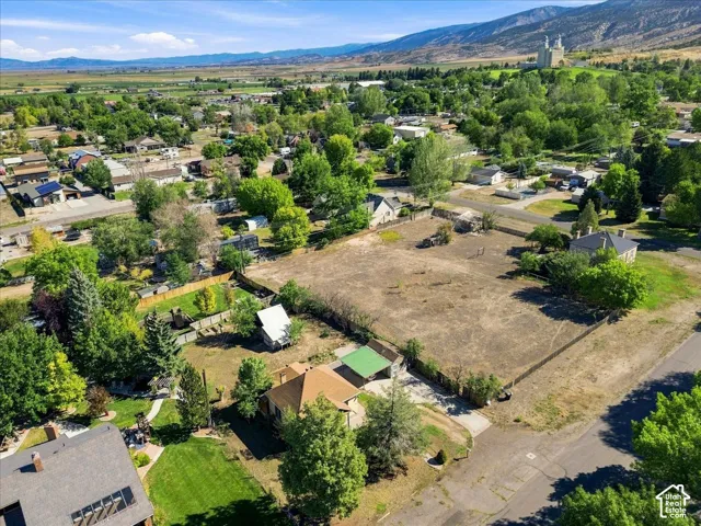 Expansive lot featuring a large open area, perimeter fencing, and established trees