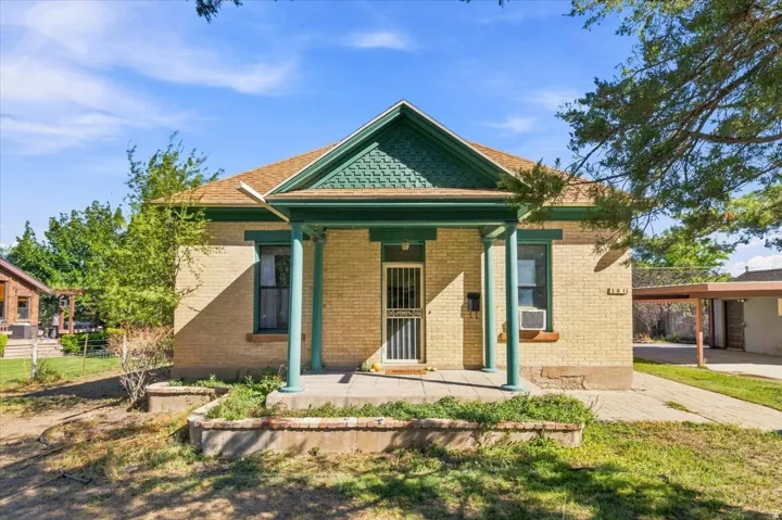 Brick exterior with a covered front porch featuring decorative pillars