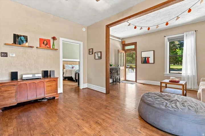 Wood-finish flooring throughout, with a wood-frame entryway and a light-filled window