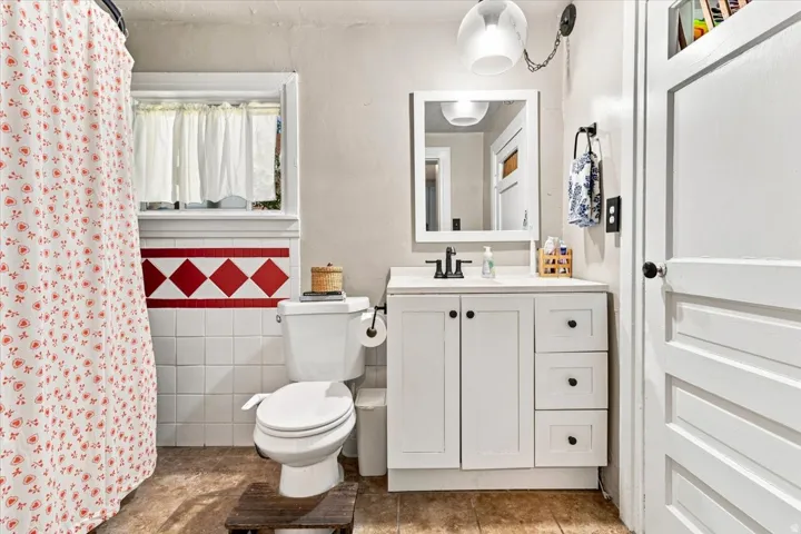 White vanity with ample storage, integrated sink, and black faucet