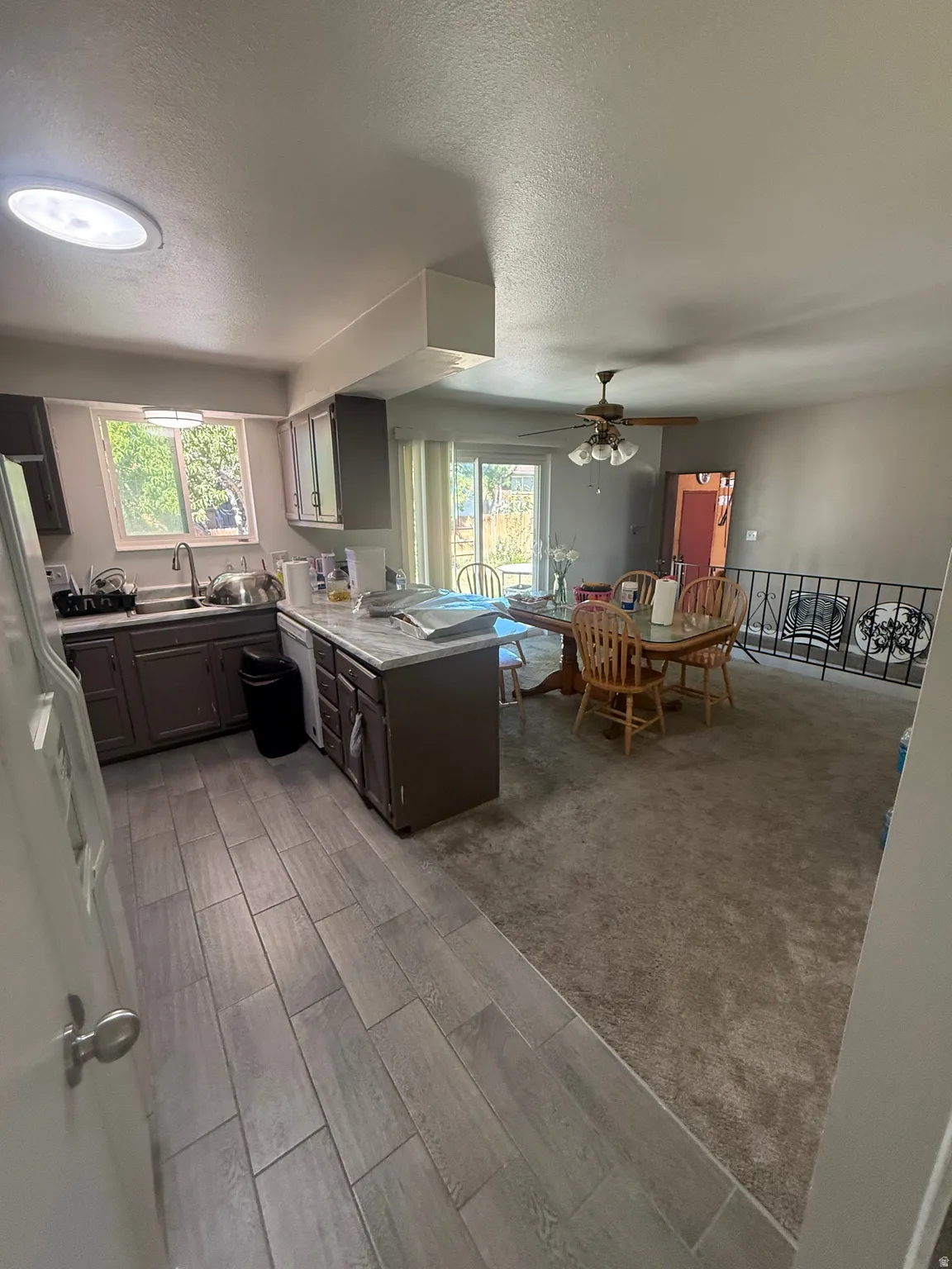 Kitchen with wood-finish flooring, dark cabinetry, and light-colored countertops