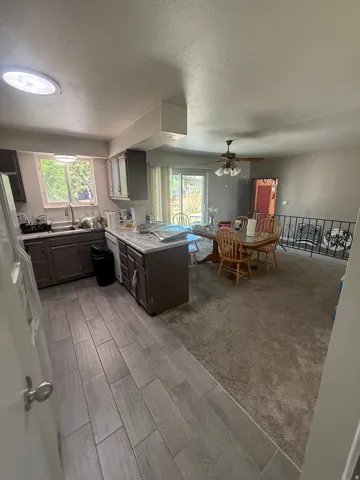 Kitchen with wood-finish flooring, dark cabinetry, and light-colored countertops