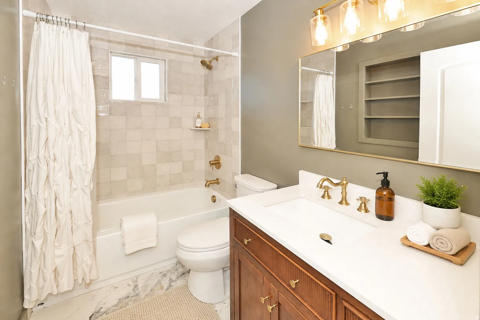 Side A upstairs Bathroom. featuring a vanity with a white countertop and wood-finish cabinetry, a built-in bathtub, and tiled walls