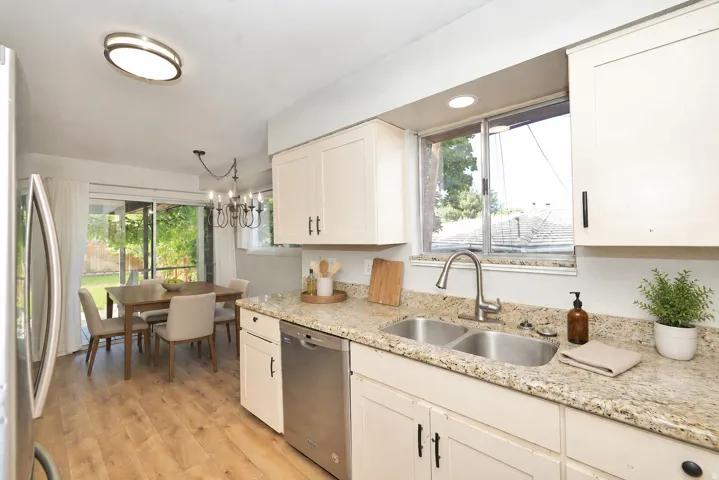 Side A Kitchen featuring light-toned cabinetry, a stainless steel double-basin sink, and a stainless steel dishwasher