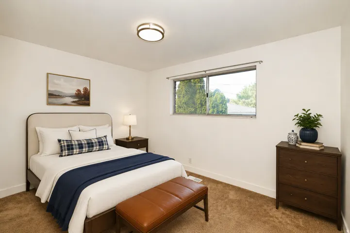 Side B bedroom 2. Wall-to-wall carpeting and a ceiling-mounted light fixture