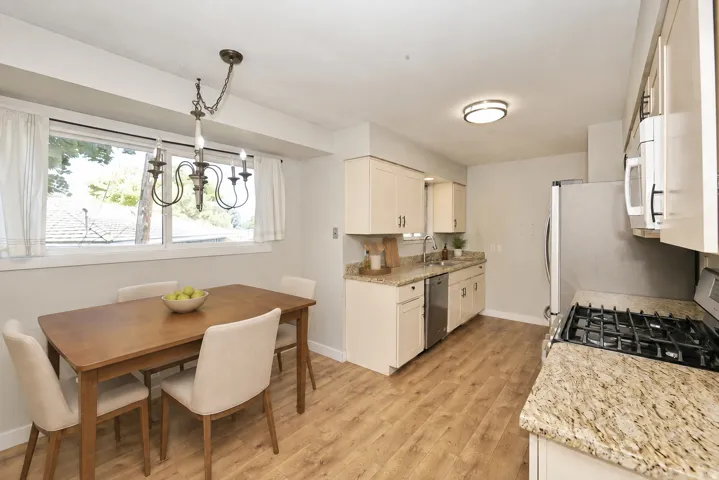 Side A Kitchen featuring wood-finish flooring, stainless steel appliances, light-toned cabinetry, and granite countertops