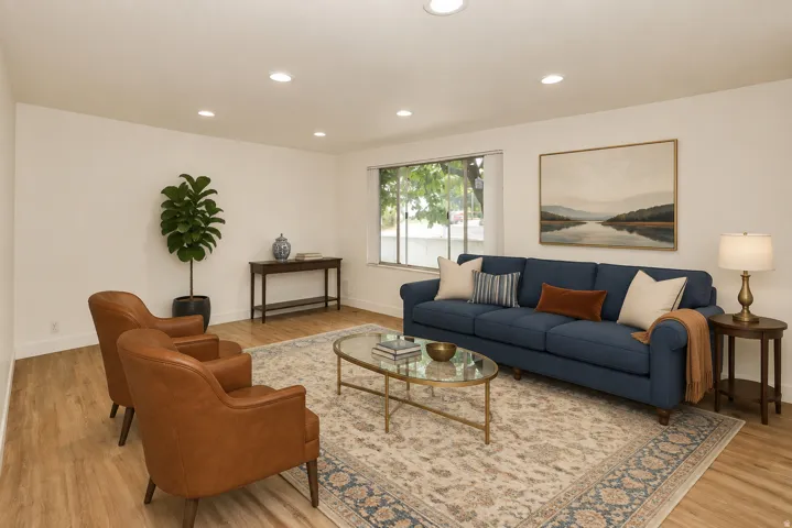 Side B Living room. Recessed lighting, wood-finish flooring, and a large window providing natural light