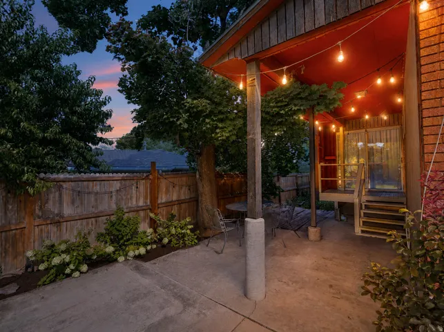 Side A private patio. Concrete patio with a wood privacy fence, mature trees, and established landscaping