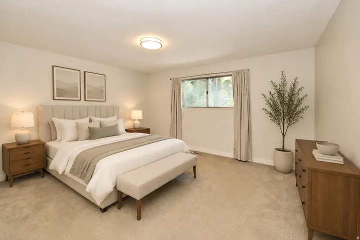 Side A primary Bedroom featuring neutral carpeting, a large window, and a flush mount ceiling light