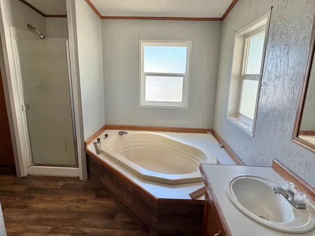 Corner soaking tub with a built-in surround, dual windows, and a separate shower enclosure