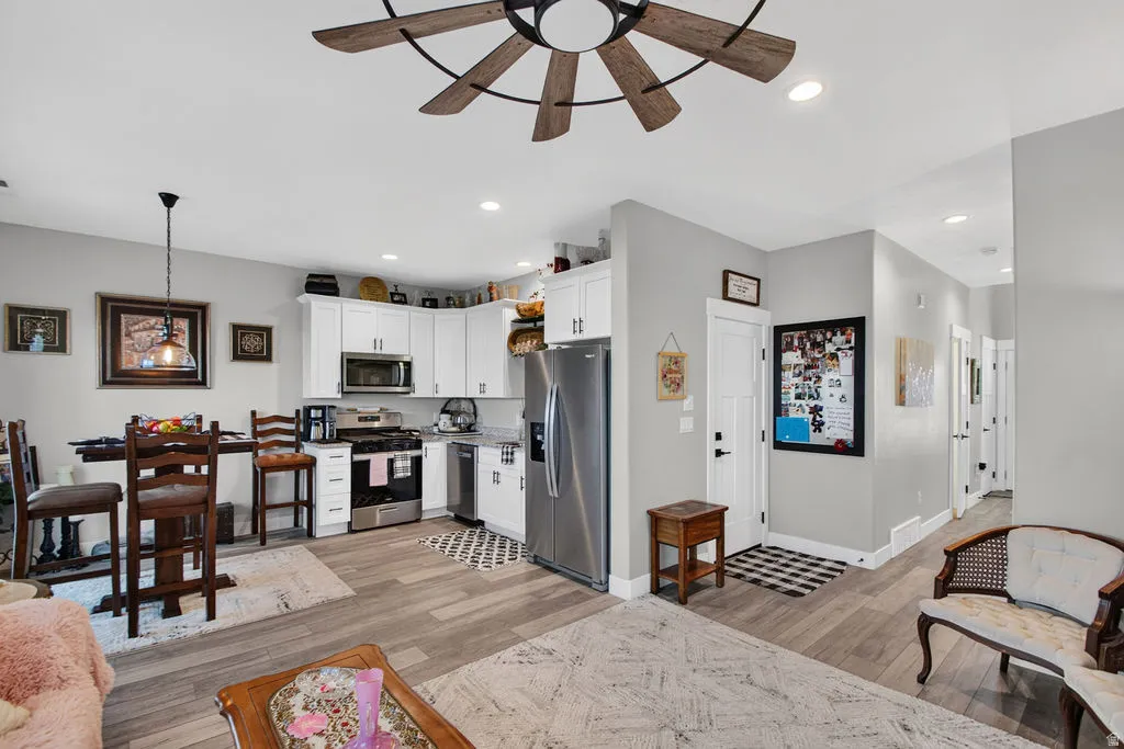 Kitchen featuring white cabinetry, stainless steel appliances, and a gas range