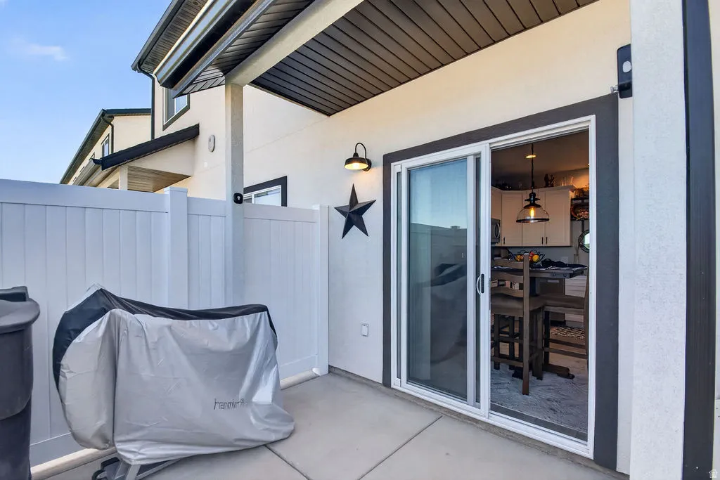 Paved patio with white vinyl fencing and a sliding glass door