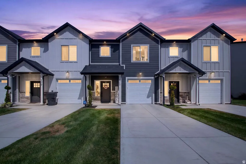 Modern townhome featuring a two-tone exterior, attached single-car garage, covered entry, and concrete driveway