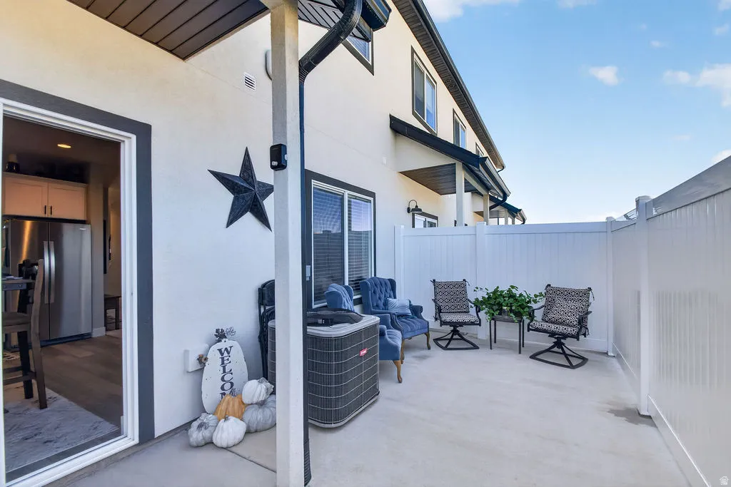 Private outdoor patio with privacy fencing, concrete surface, and direct access to an interior space