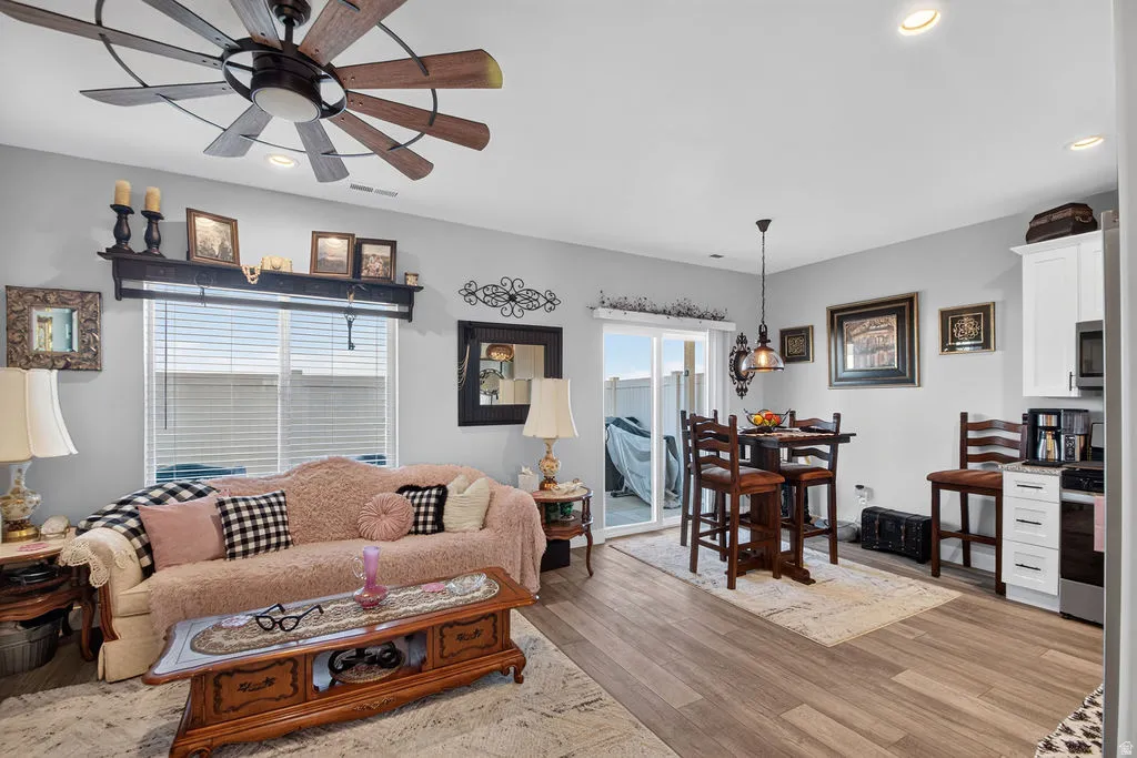 Open-concept living space featuring wood-finish flooring, recessed lighting, and a sliding glass door