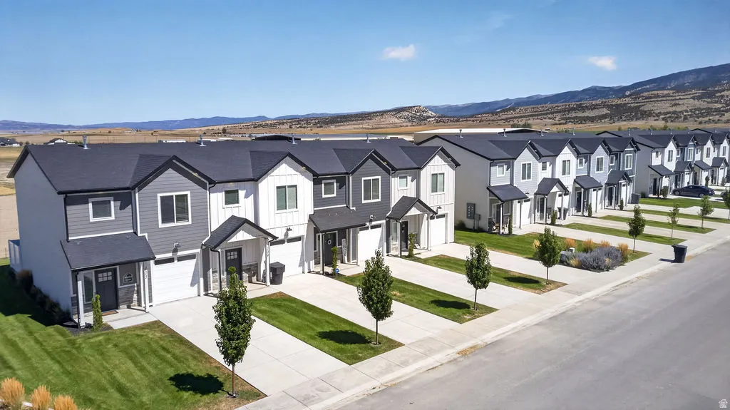 Newly constructed townhomes with varying exterior siding, individual driveways, and attached single-car garages