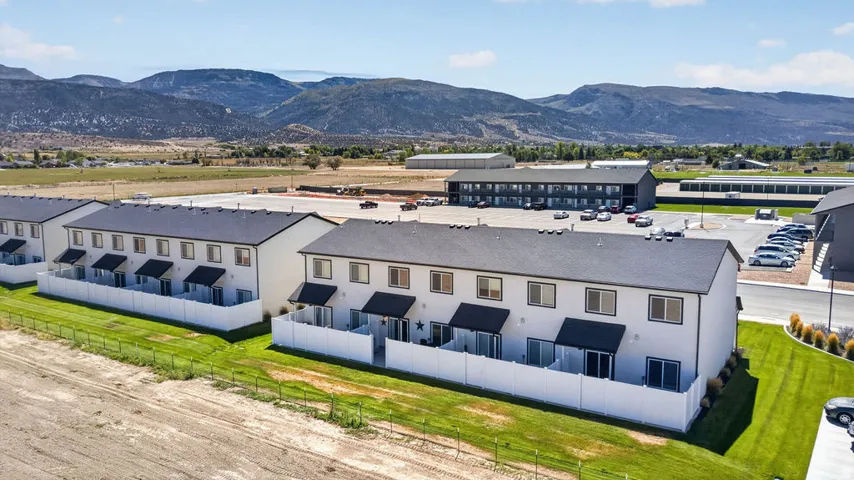 Modern townhouse exteriors with private patios, individual awnings, and white privacy fencing