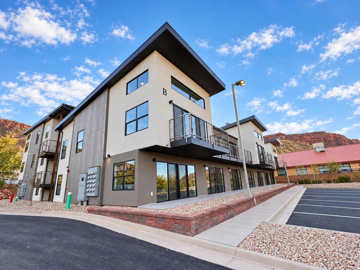 Contemporary building exterior featuring a stucco and vertical wood-finish facade